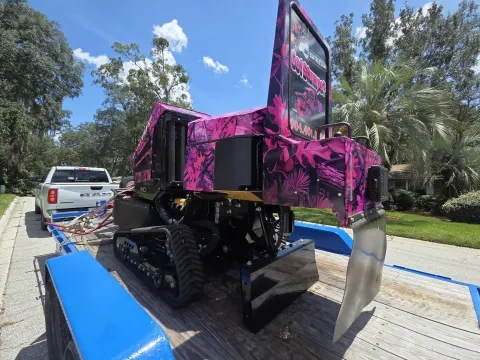 904Tree pink camo tracked stump grinder loaded on a blue equipment trailer showing the Got Stumps? 904TREE.com branding, ready to roll to the next Jacksonville, FL job